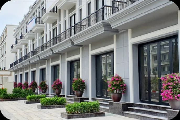 Cận cảnh mặt tiền tầng trệt dãy nhà liền kề HUD Sơn Tây với chậu hoa trang trí trước cửa kính.