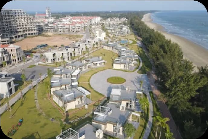 Toàn cảnh trên cao khu nghỉ dưỡng Longbeach với khối khách sạn, dãy biệt thự và bãi biển phía xa.
