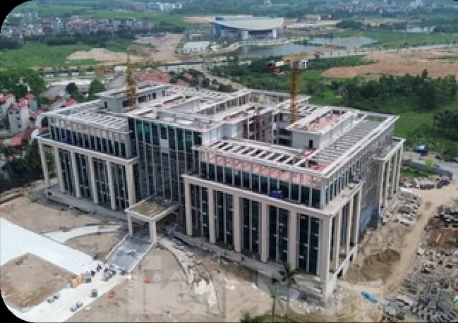 Toàn cảnh công trường Trung tâm hành chính Đông Anh nhìn từ xa với cần cẩu tháp đang thi công.